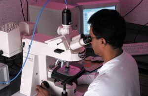 Siddharth Mittal tapped as Syngene CEO to navigate contract research sector headwinds Research scientist analysing a sample under a microscope, illustrating contract research and biopharmaceutical development