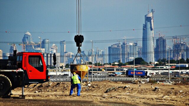 Construction cranes and workers on a Dubai building site