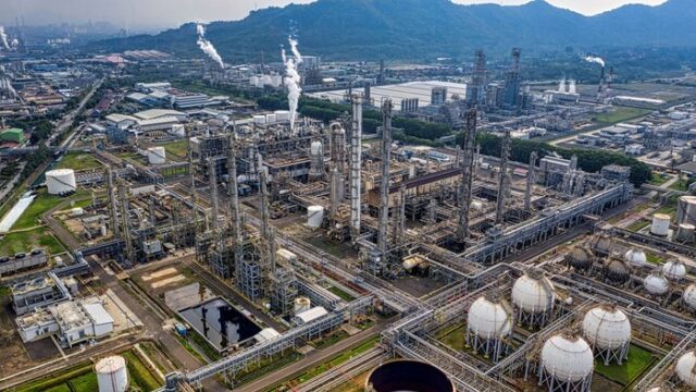Aerial view of an oil refinery complex in daylight, illustrating the downstream energy sector