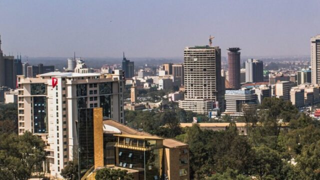 Daylight view of an African city commercial district with office towers and tree cover, a generic stock illustration that does not depict any property owned or managed by the companies named in this report.
