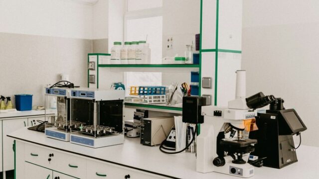 A clinical laboratory bench with analytical instruments and a microscope, the molecular diagnostics market in which QIAGEN operates