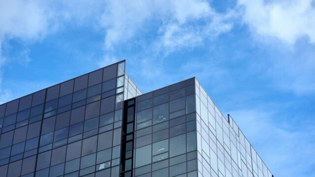 em-xbox-20261025am A glass-fronted corporate technology office building under a clear daytime sky