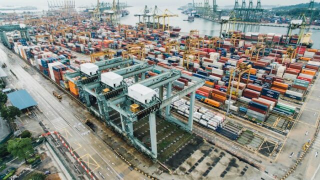 Intermodal shipping containers stacked on a busy container dock