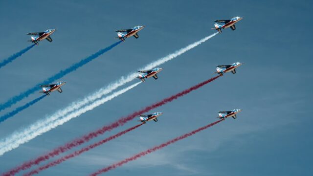 Jets flying in close formation leaving coloured smoke trails at an airshow